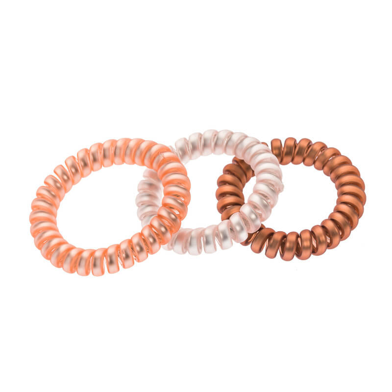 3 elastische haarbanden van Stella Green in bruin, wit en oranje.
